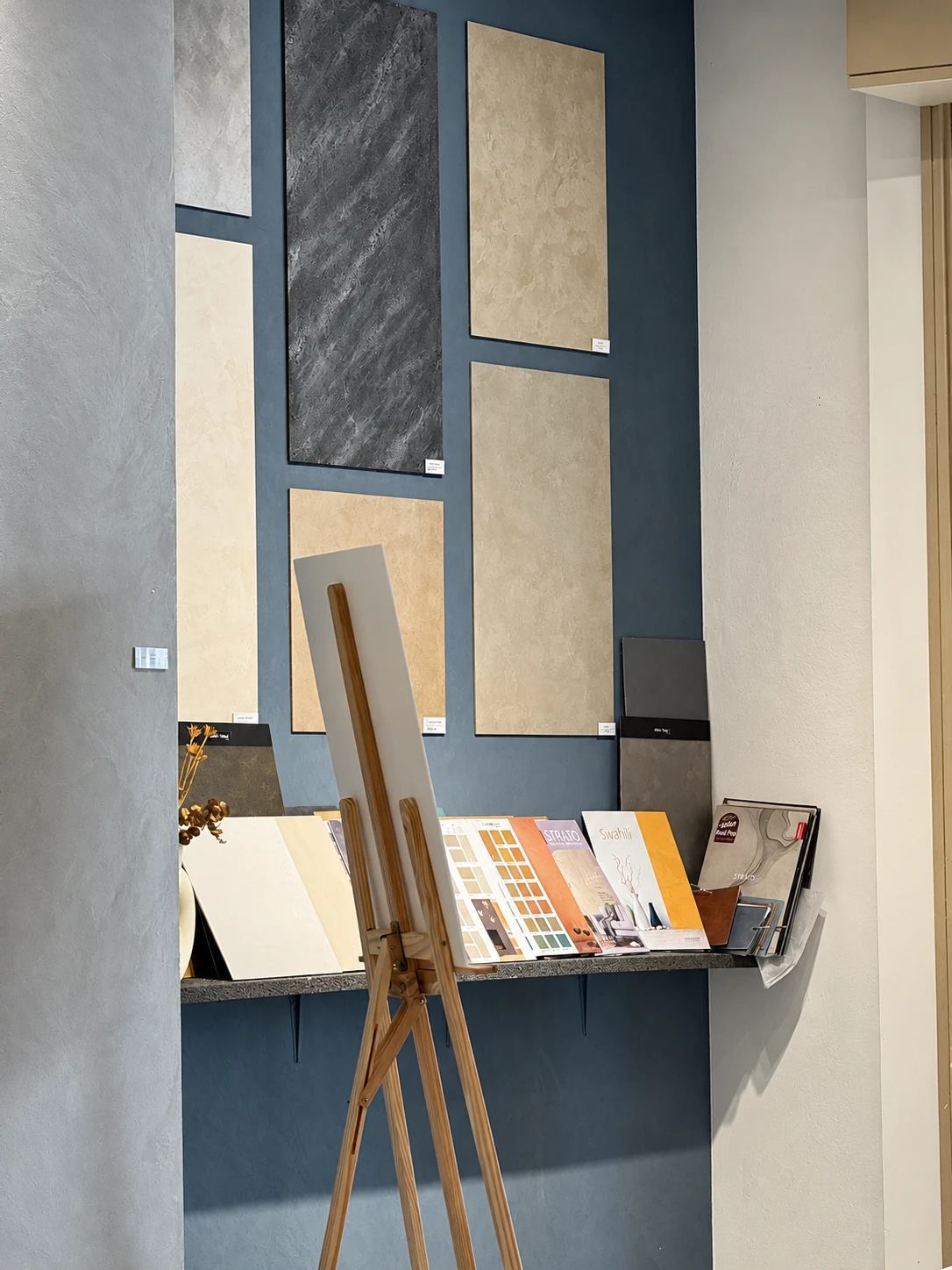 Sample panels on a blue limewash wall in the showroom